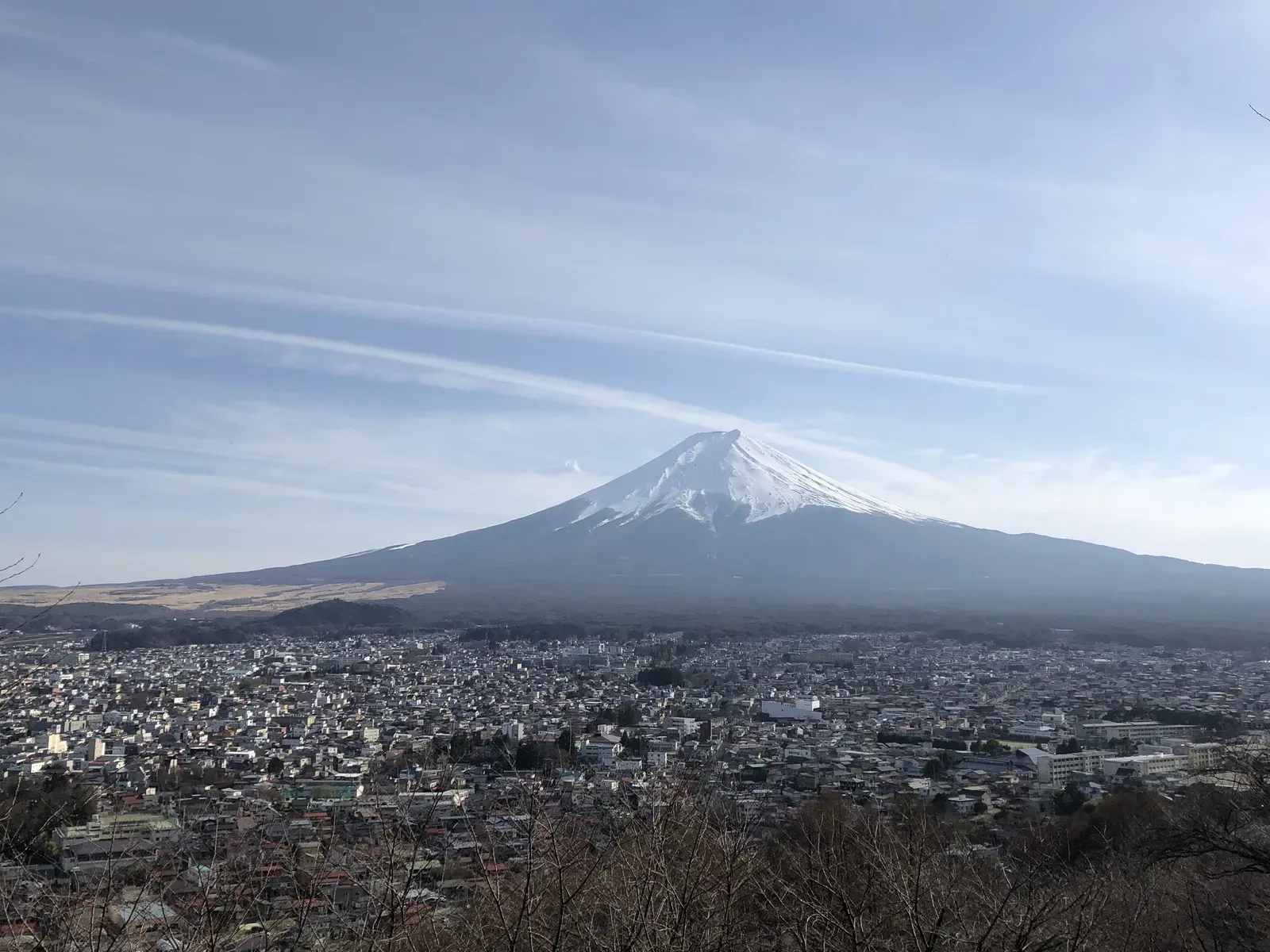 Snow-capped volcano rising above a low winter town.